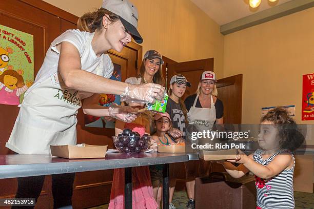 Betsy Brandt, Samantha Harris, Lola Ray Facinelli, Jennie Garth, Hillary Madison Hess , and Josselyn Sydney Hess serve lunch to kids at the Feeding...