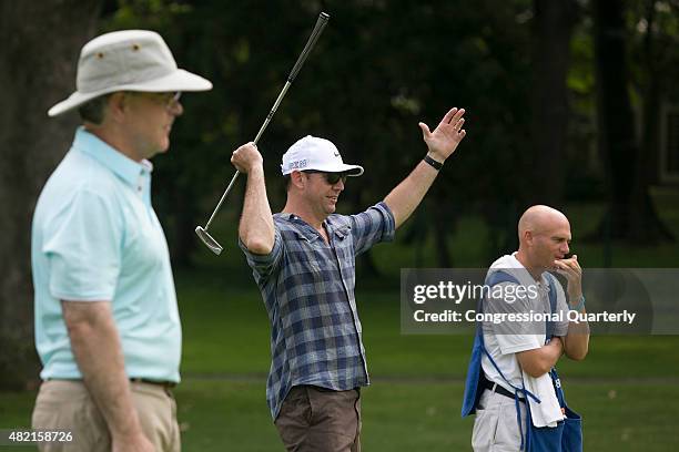 Rep. Duncan Hunter, R-Calif. Celebrates as his teammates ball goes in the hole as Rep. Jim Cooper, D-Tenn., left, looks on at hole 7 during the First...