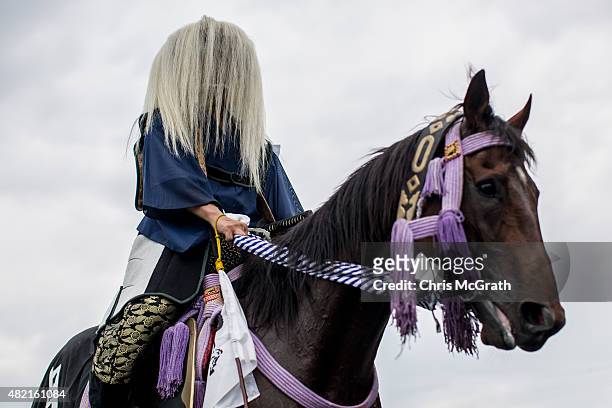 Samurai horseman waits for a parade to start after the morning ritual at Ohta Shrine ahead of the the Soma Nomaoi festival on July 25, 2015 in...