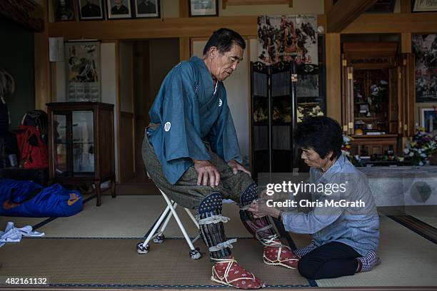 Yoshikatsu Mottate , 72 is assisted by his wife Masako as he gets dressed into traditional clothing at his home prior to taking part in the Soma...