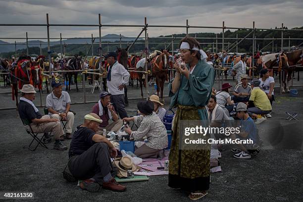 Soma Nomaoi festival participants enjoy a meal at the Ohta Shrine while waiting for the parade to start ahead of the days racing on July 25, 2015 in...