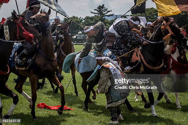 Samurai horsemen fight for a flag during the Shinki-soudatsusen at the Soma Nomaoi festival at Hibarigahara field on July 26, 2015 in Minamisoma,...