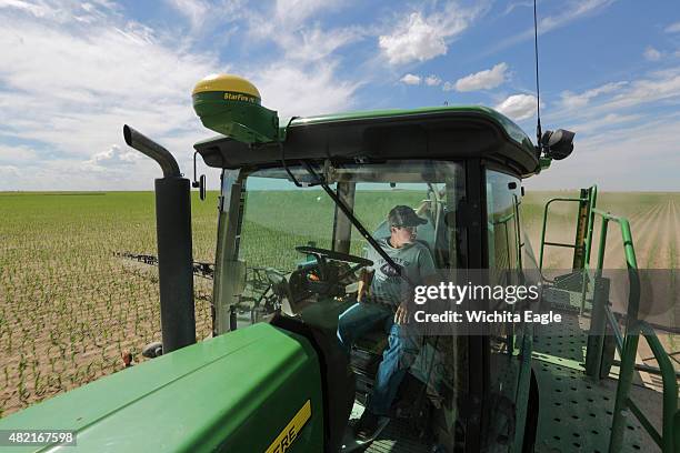 Braden Scott drives a crop sprayer over an irrigated corn field on June 9, 2015 near Ulysses, Kan. Braden Scott is of the three sons of farmer Clay...