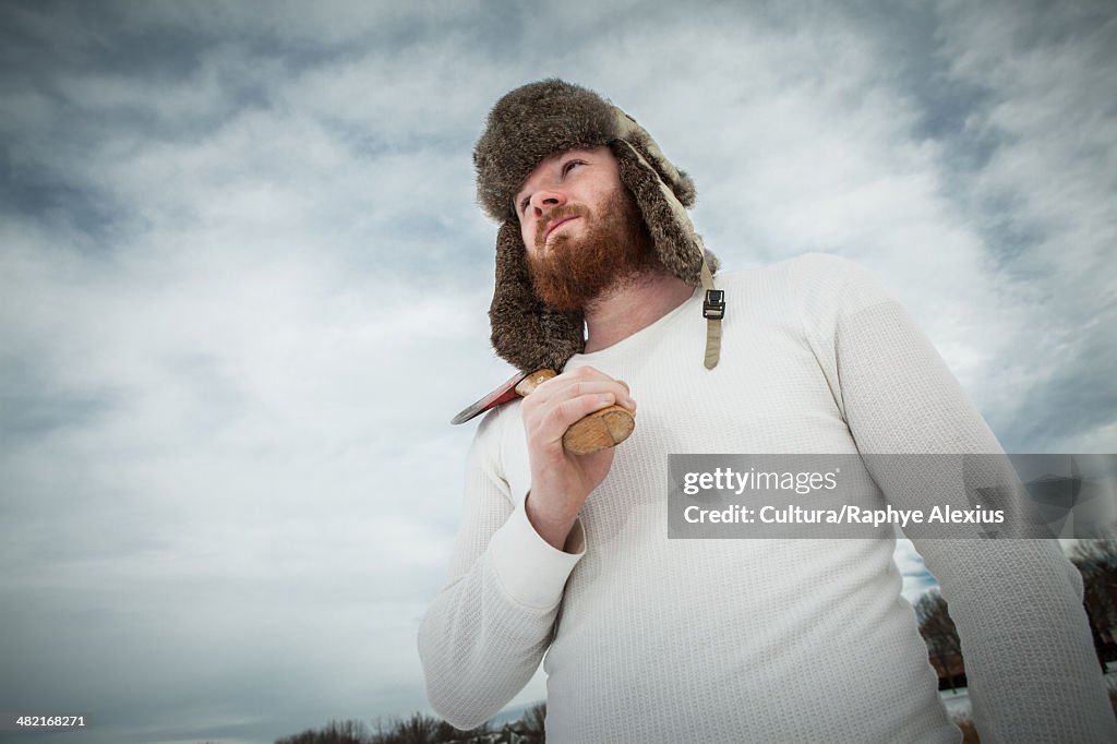 Heroic portrait of young man holding an axe