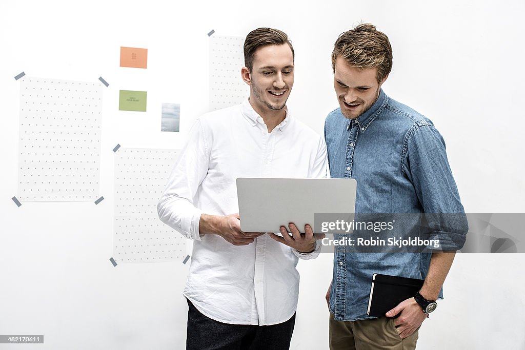 Male colleagues using laptop