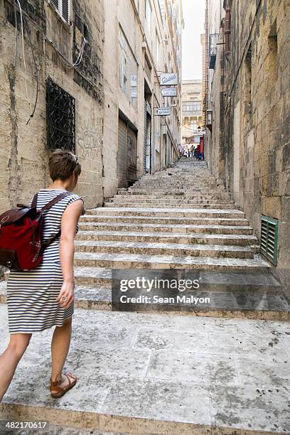 female tourist walking up stairs, valletta, malta - sean malyon stock pictures, royalty-free photos & images