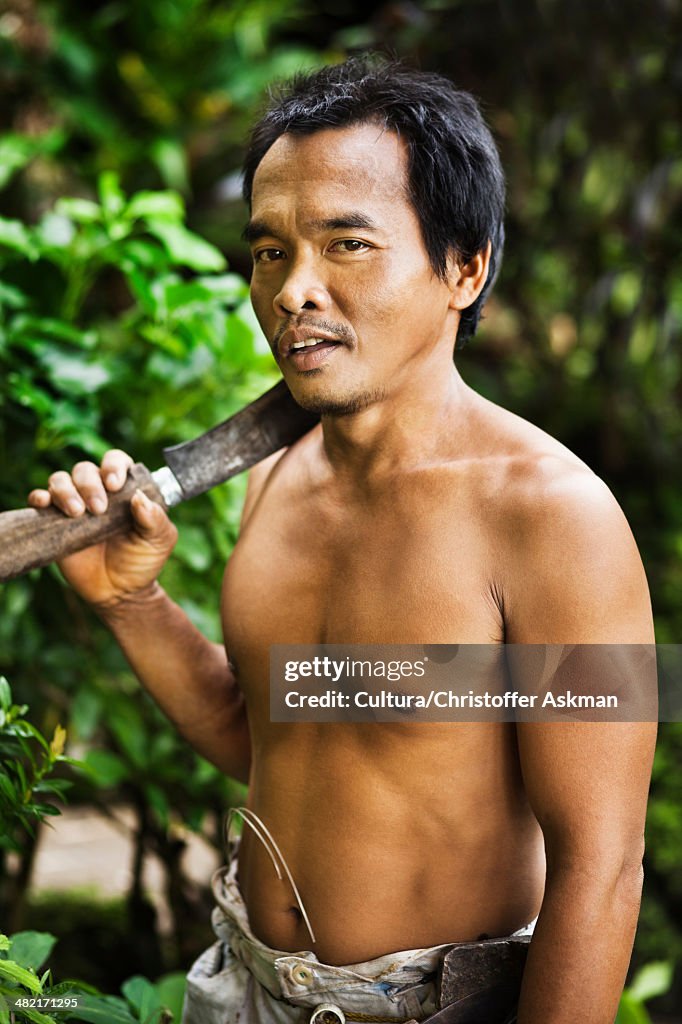 Man carrying machete in tropical forest