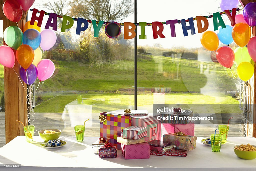 Table laid with birthday gifts and balloons