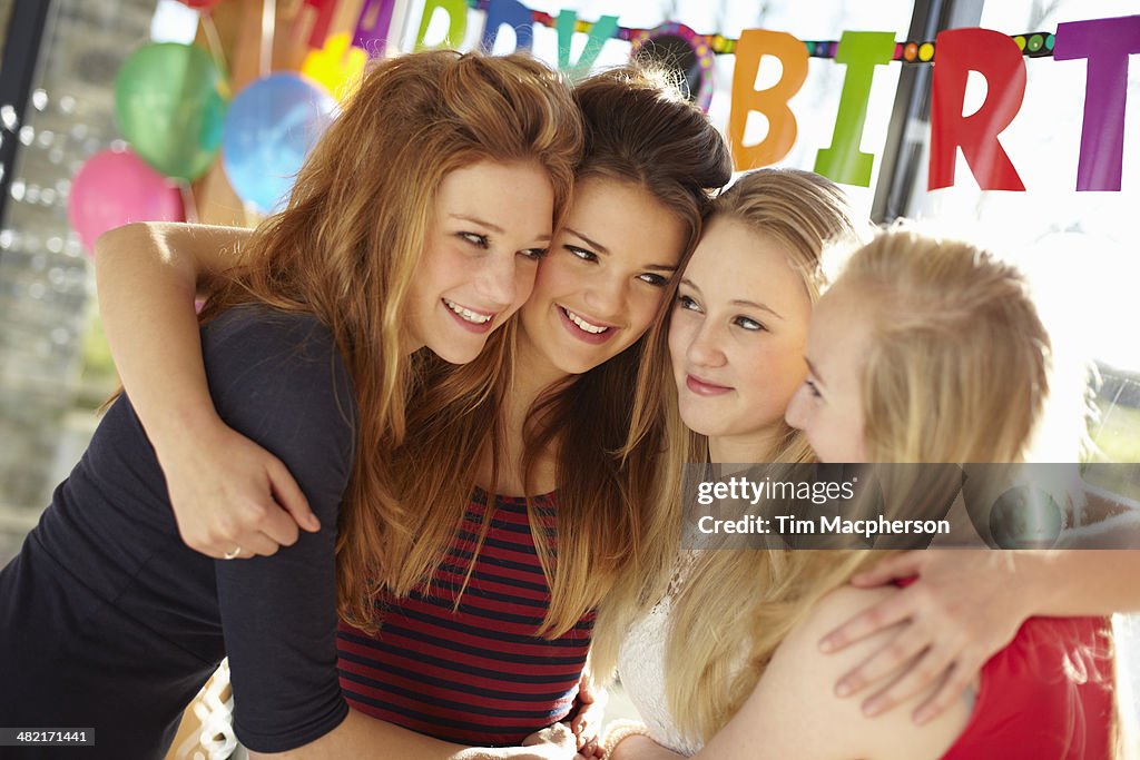 Four teenage girls celebrating at birthday party