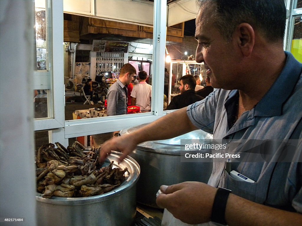 A vendor prepares the food inside his stall at Tasjeel is an...