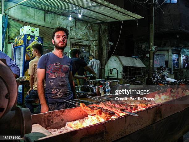 Man stands in front of the meat grill at Tasjeel is an old place in UNESCO. The people in Tasjeel say, they live without change just like the old...