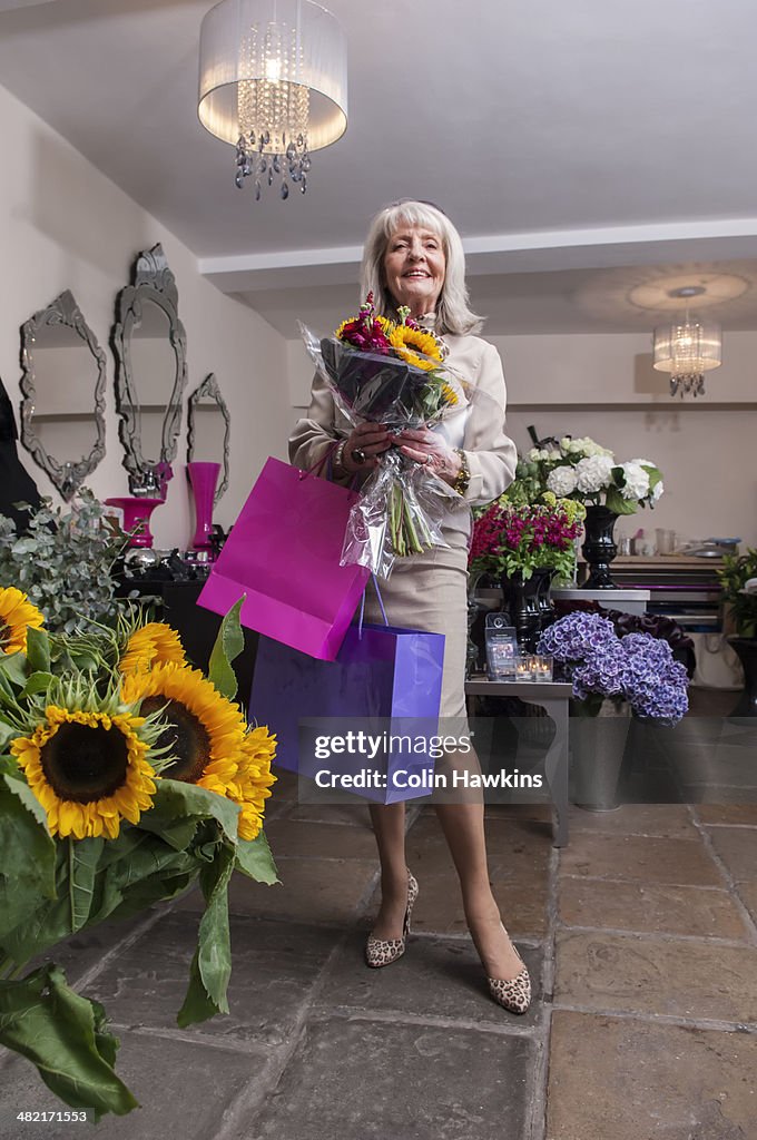 Senior woman shopping for flowers in florist shop