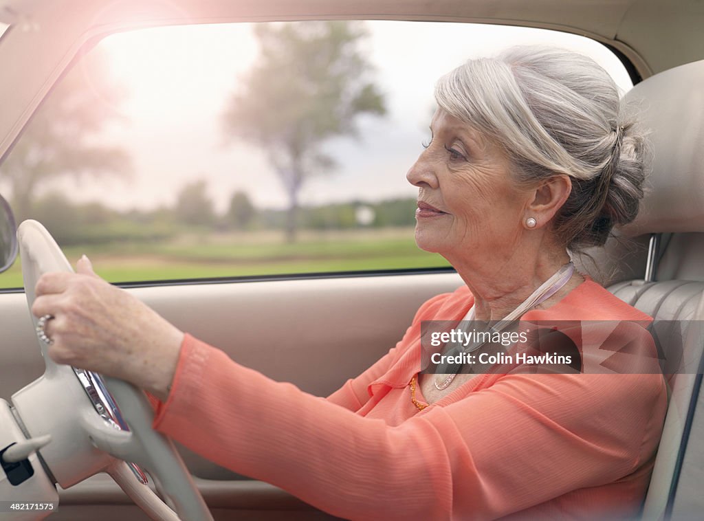 Elegant senior woman driving in car