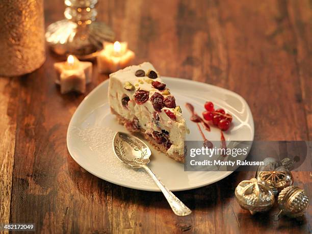 mascarpone cheesecake with cranberry, pistachio, orange zest and chocolate chip amongst festive decorations - christmas cake stock pictures, royalty-free photos & images