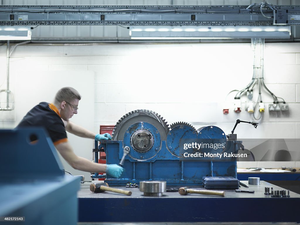 Engineer assembling industrial gearbox in engineering factory