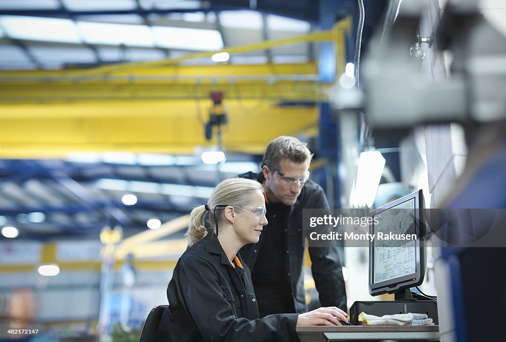 Engineers Using Computer To Work On Plans In Engineering Factory High ...