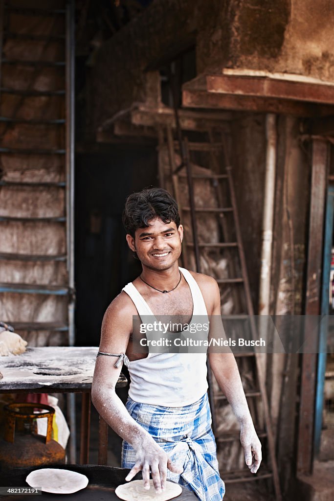 Smiling man grilling flatbread outdoors