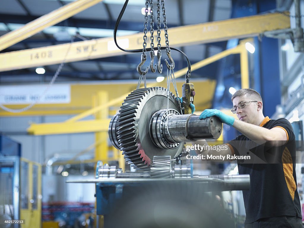 Engineer assembling industrial gearbox in engineering factory