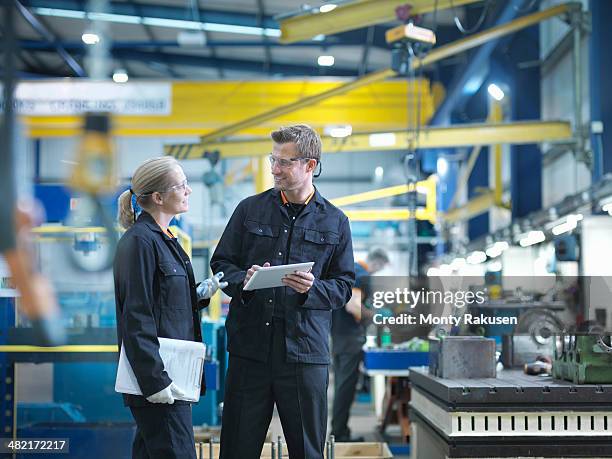 workers in discussion in engineering factory - coveralls stock pictures, royalty-free photos & images