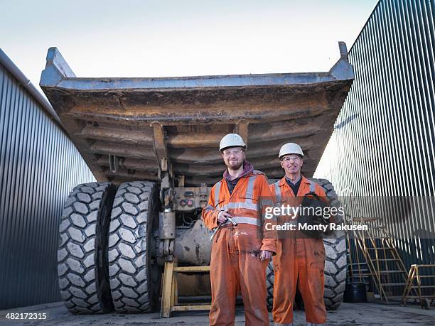 father and son engineers in engineering workshop, portrait - miner helmet portrait stock pictures, royalty-free photos & images