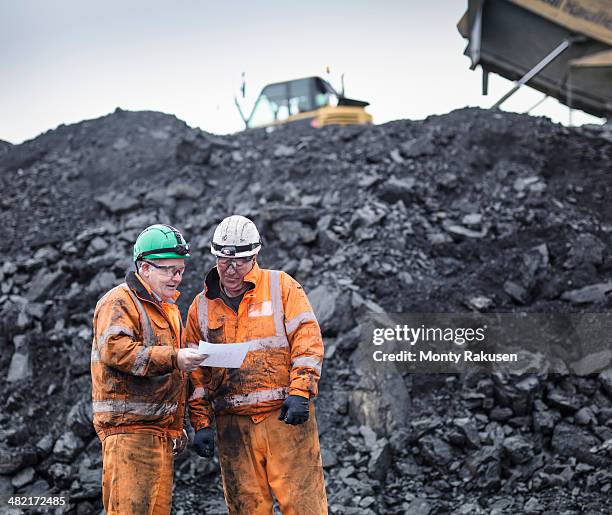 workers in discussion in front of coal stocks in surface coal mine - coal miner stock pictures, royalty-free photos & images