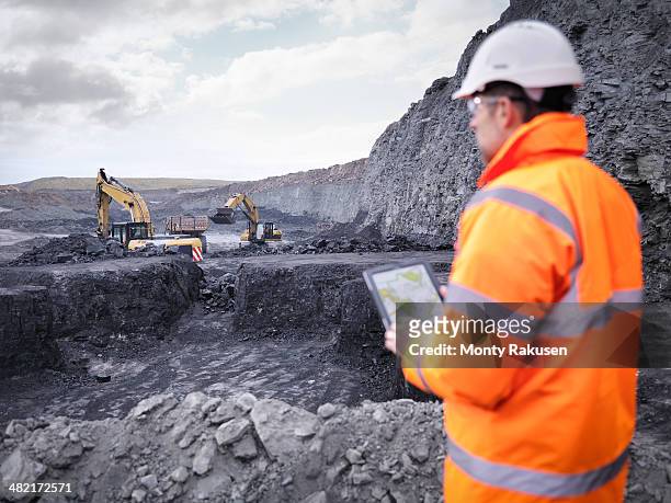 miner checks plans on digital tablet in surface coal mine - coal mine 個照片及圖片檔