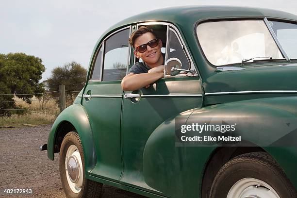 portrait of young man in vintage morris minor - car attitude stock pictures, royalty-free photos & images