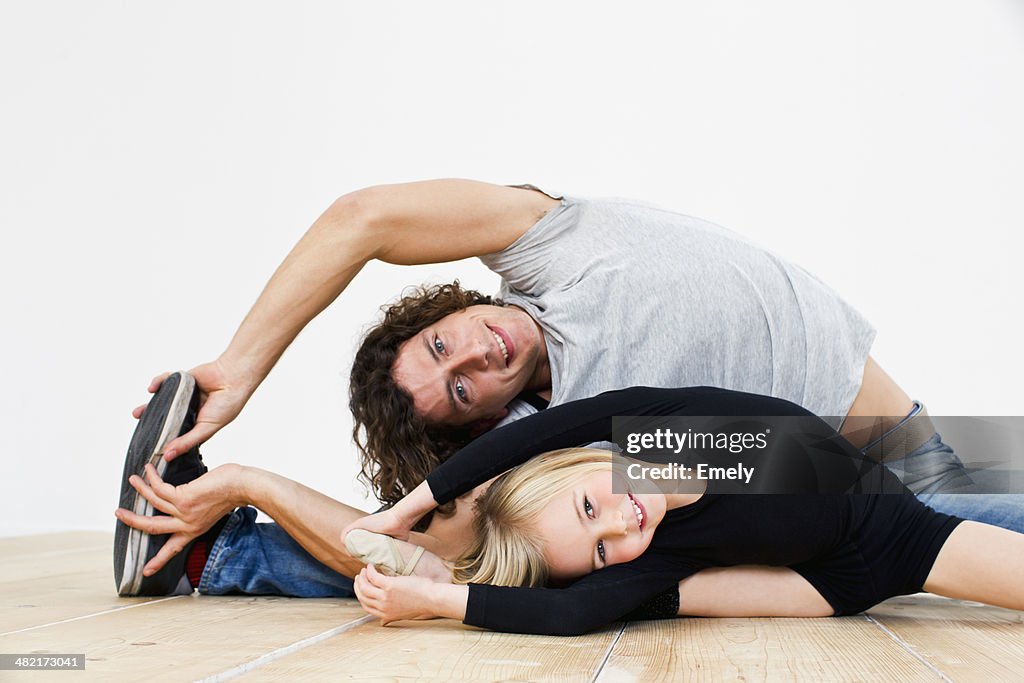 Studio shot of father and ballerina daughter doing splits