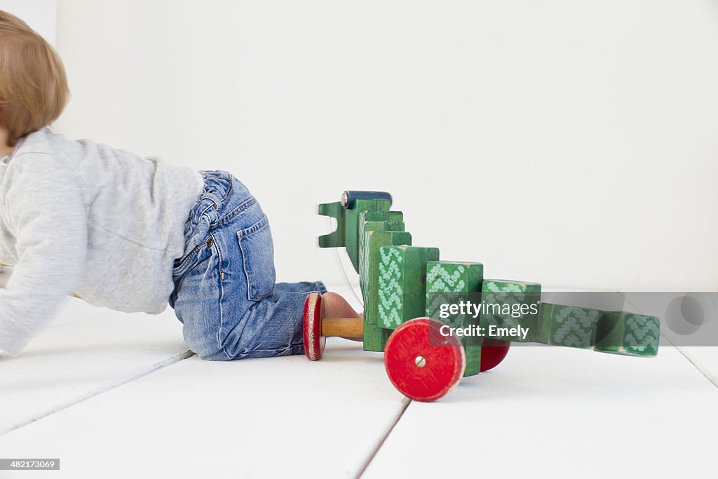 Studio shot of baby girl and wheeled toy