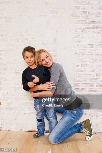 studio portrait of mother kneeling next to son - boy curly blonde stock pictures, royalty-free photos & images