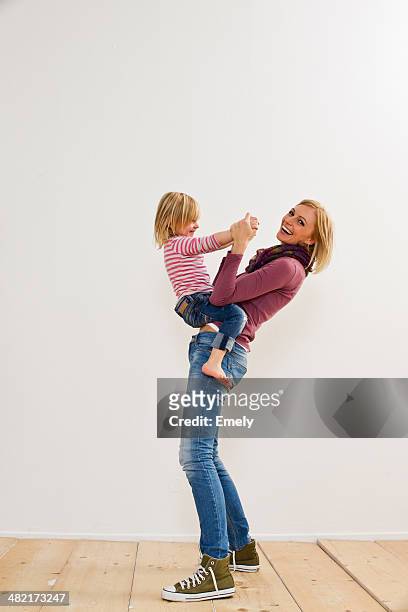 studio portrait of mother playing with young daughter - family white background stock pictures, royalty-free photos & images