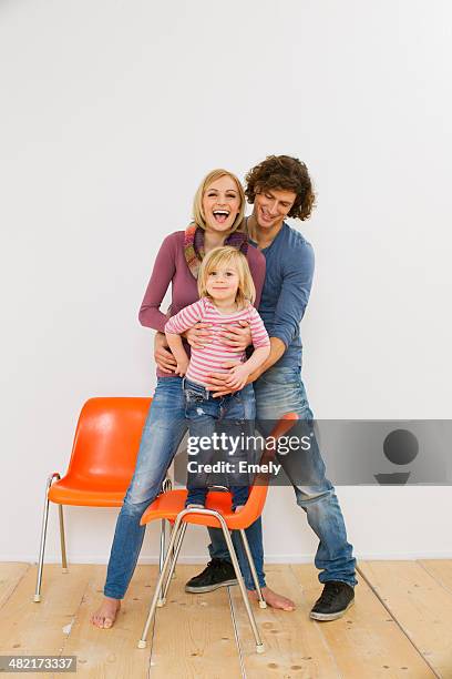 studio shot of couple with young daughter standing on chair - family studio shot stock pictures, royalty-free photos & images