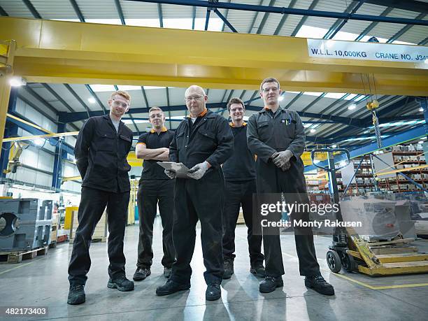 group of engineers and apprentices in engineering factory, portrait - monty rakusen portrait stock pictures, royalty-free photos & images