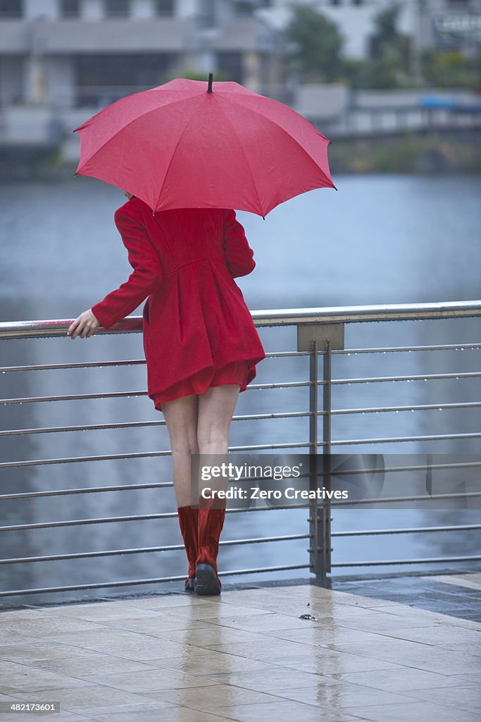 Young woman in red waiting by waterfront