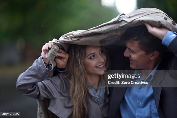 young woman and mature man walking in park - shower hug stock pictures, royalty-free photos & images