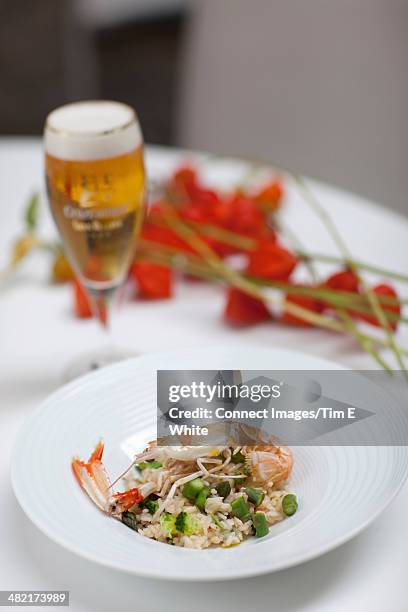 plate of langoustine paella with beer - paella alicante stock pictures, royalty-free photos & images