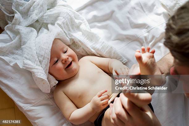 father playing with baby daughter - changing diaper imagens e fotografias de stock