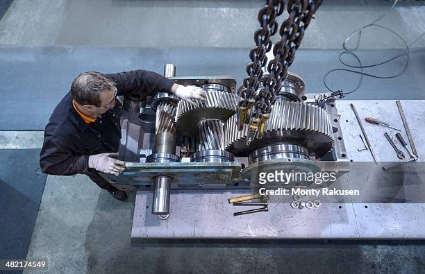 overhead view of engineer repairing industrial gearbox in factory - engineer gearwheel factory stockfoto's en -beelden