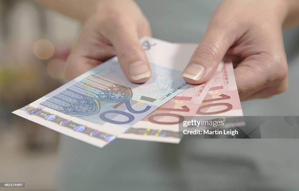 Female hands holding ten and twenty euro notes