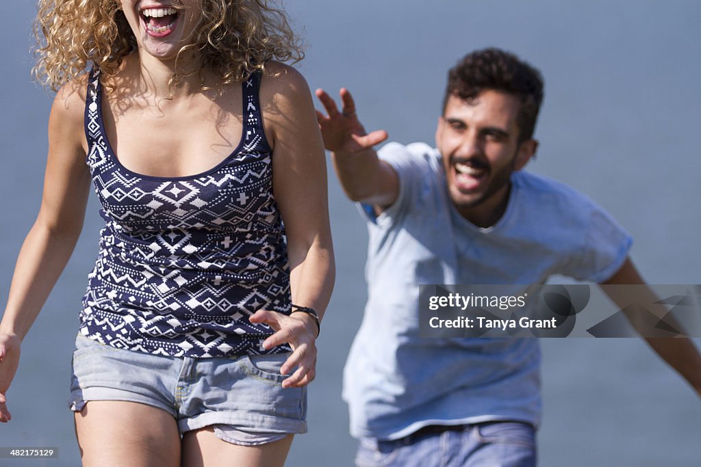 Young man chasing woman, laughing