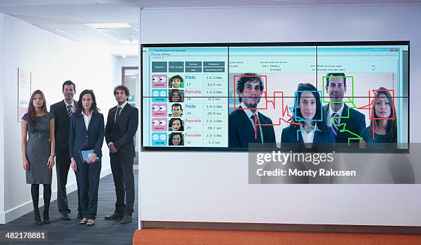 portrait of office workers standing next to face recognition software system - facial recognition technology stock pictures, royalty-free photos & images