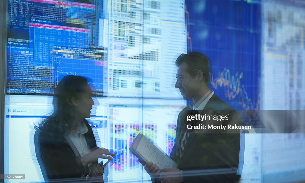 Reflection of business people in front of screens
