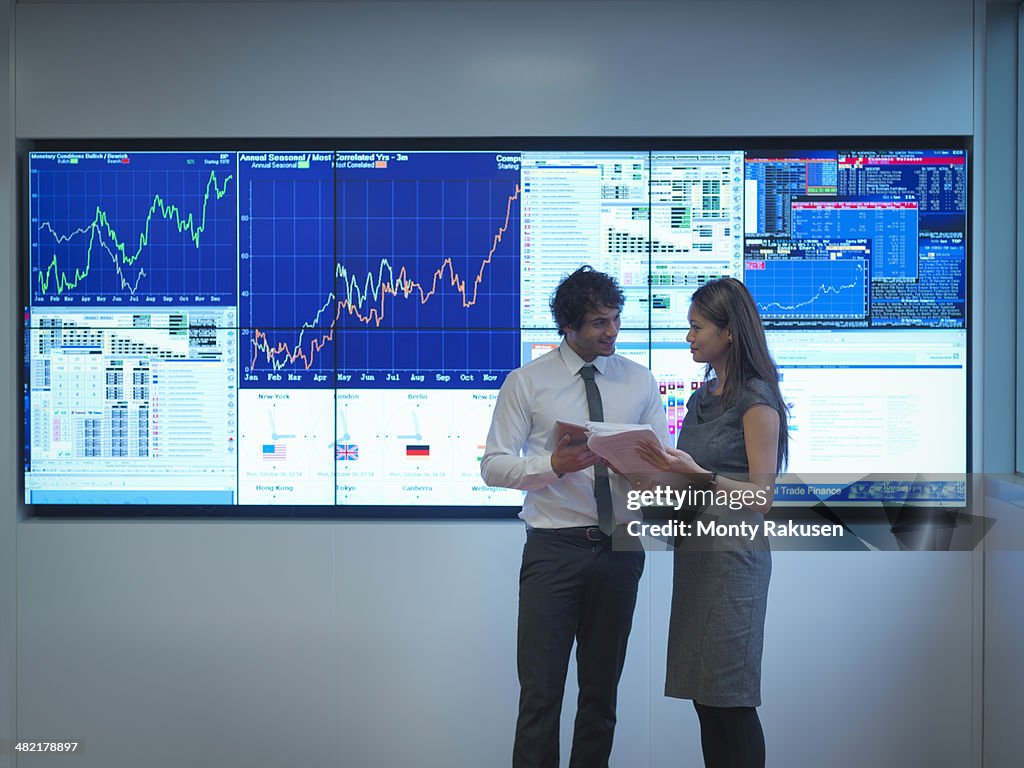Business people meeting in front of graphical screens
