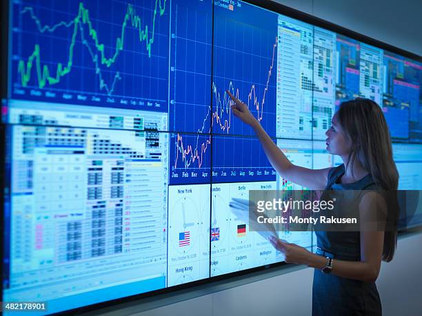 businesswoman preparing presentation on graphical screens - business woman pointing stock-fotos und bilder