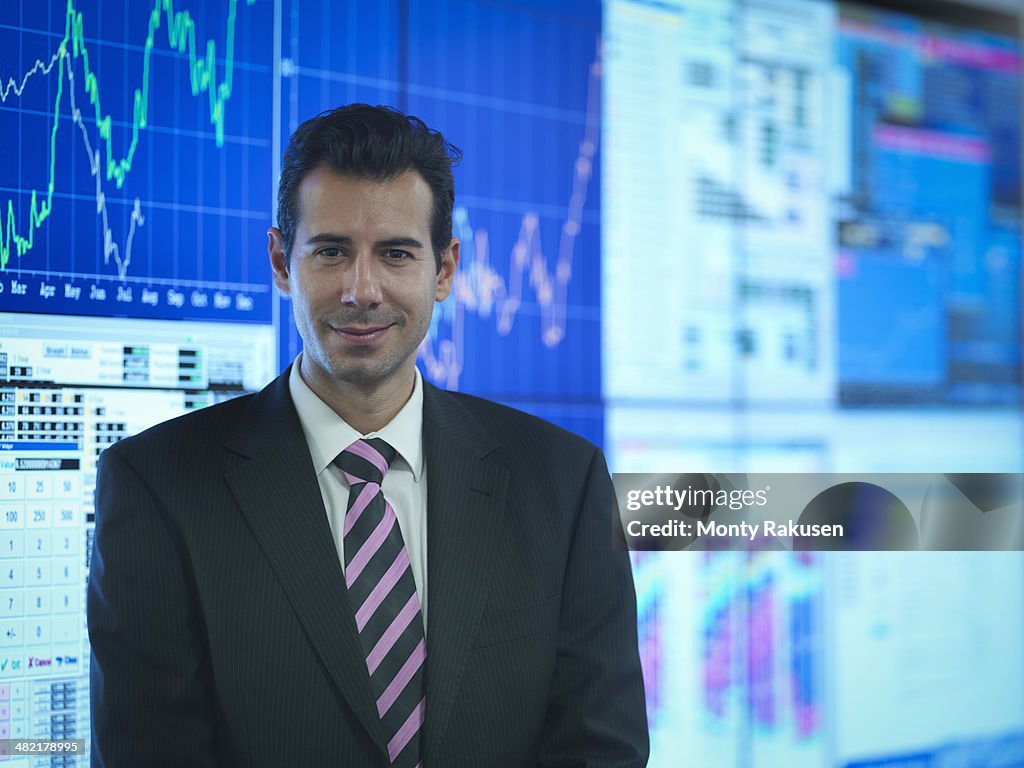 Portrait of businessman in front of presentation on graphical screens