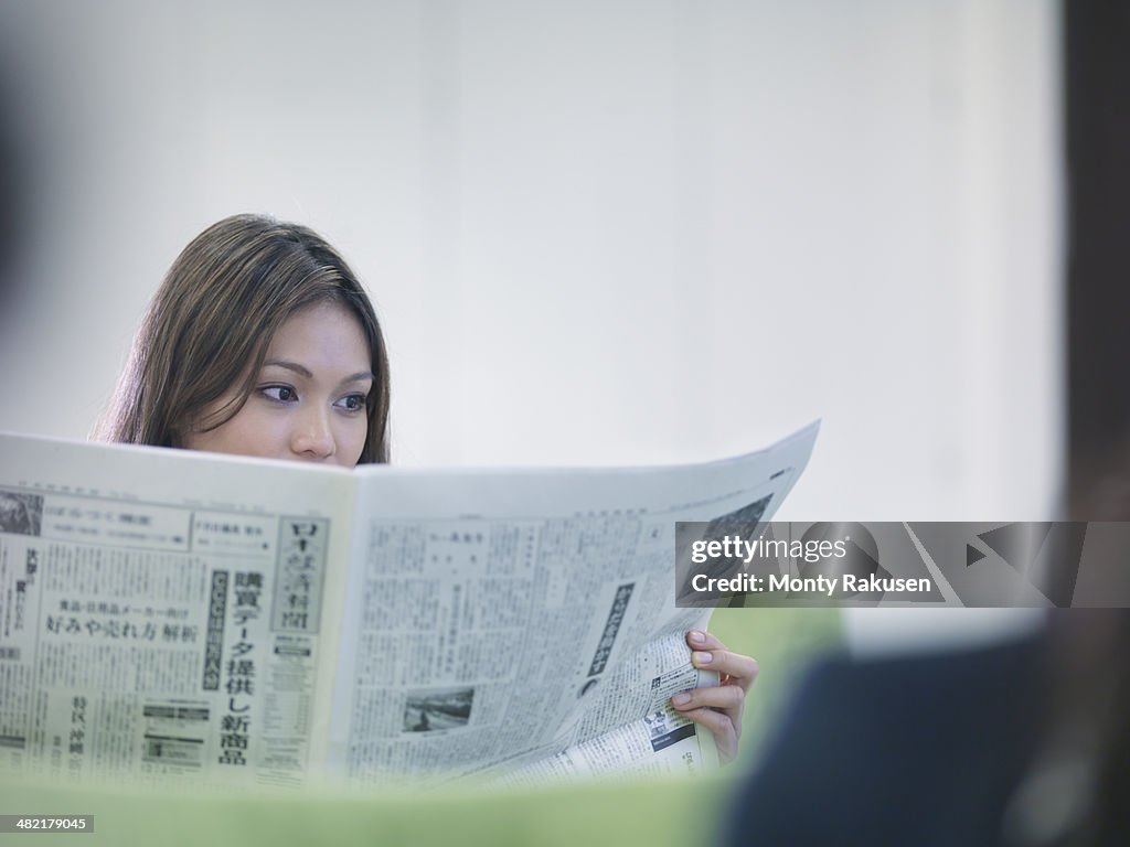 Businesswoman reading Japanese newspaper