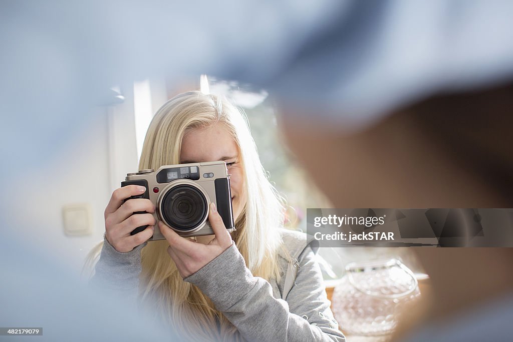 Teenage girl photographing friend with camera