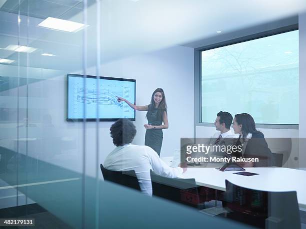 view through glass wall of business colleagues using screen in meeting - south ruislip stock pictures, royalty-free photos & images
