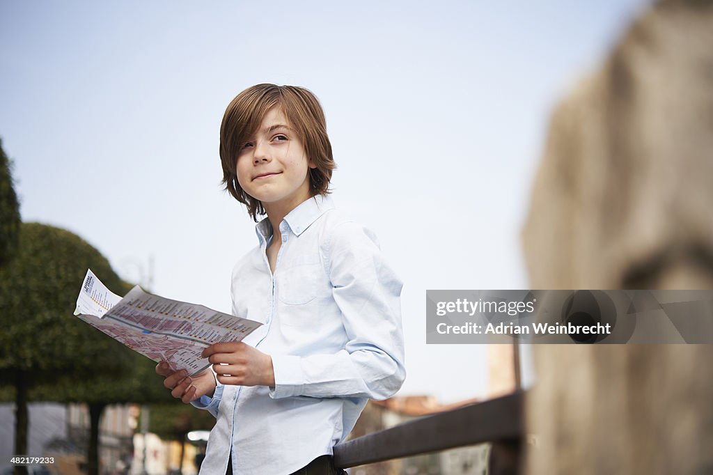 Young boy looking at map in park, Province of Venice, Italy