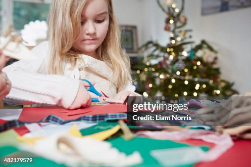 Young girl cutting out paper with scissors Young girl cutting out paper with scissors